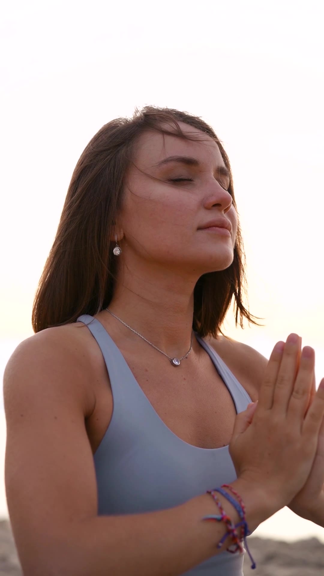 A woman with her hands at her heart in the evening light